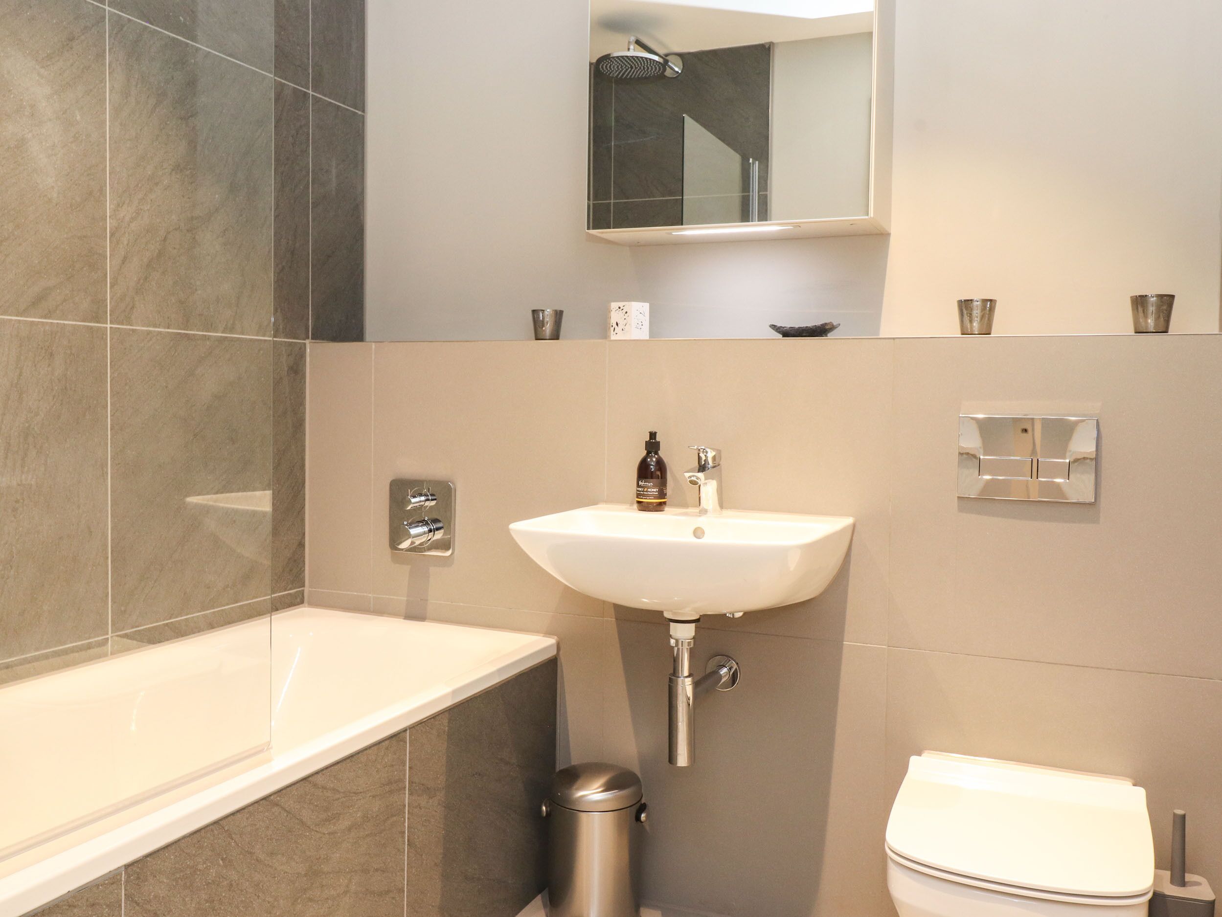 A modern bathroom with a bathtub, sink, and toilet.
