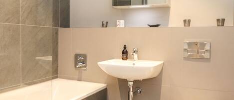 A modern bathroom with a bathtub, sink, and toilet.