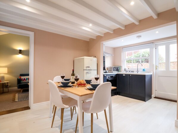 Een moderne keuken met witte kasten, een zwart aanrecht en een raam.