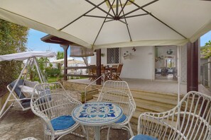 An outdoor patio with white wicker furniture, a covered seating area, and a view of the interior. - 2335 Villetta Ada by Barbarhouse (Porto Cesareo)