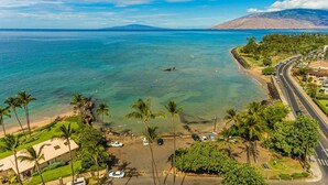 A coastal view with a beach, palm trees, and a road. - The Cove Hale 4 Bedroom Home (Kihei)