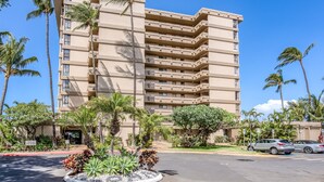 Un hôtel à plusieurs étages au design moderne, doté de balcons et d’un jardin paysager agrémenté de plantes tropicales.