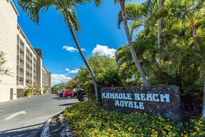 A sign for 'Kahoola Beach Royale' with a clear sky and palm trees. - Kamaole Beach Royale 206 1 Bedroom Condo (Kihei)