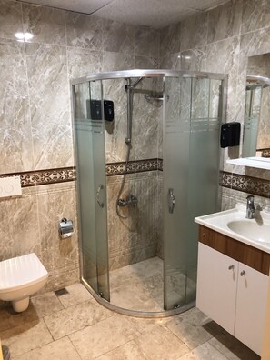 A modern bathroom with a glass-enclosed shower, a white sink, and a toilet. - Punta Vista (Izmir)