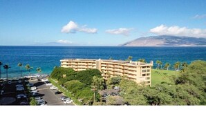 A beachfront hotel with multiple floors, a parking lot, and a view of the ocean. - Kihei Surfside, #111 1 Bedroom Condo by RedAwning (Kihei)