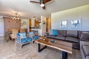 A spacious living area with a wooden coffee table, a sofa, and a dining set. - Wailea Ekahi, #33b 1 Bedroom Condo by RedAwning (Kihei)