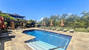 A swimming pool with lounge chairs and umbrellas, surrounded by palm trees and a clear sky. - Wailea Elua, #0908 2 Bedroom Condo by RedAwning (Kihei)