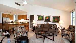 A modern living room with a sofa, chairs, a coffee table, and a kitchen in the background. - Wailea Elua, #0908 2 Bedroom Condo by RedAwning (Kihei)