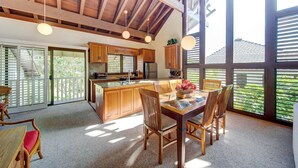 A spacious kitchen with wooden cabinets, a central island, and large windows. - Kauai Kiahuna Plantation by Coldwell Banker Island Vacations (Koloa)