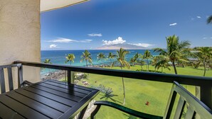 A balcony with a view of a golf course, ocean, and distant mountains. - Kihei Surfside, #609 1 Bedroom Condo by RedAwning (Kihei)
