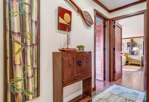 Un mueble de madera con cajones, un adorno en la pared y una puerta que da a otra habitación.