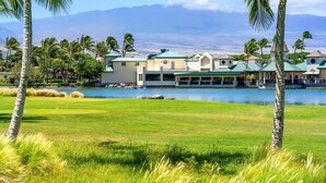 A resort with multiple buildings, a lake, and palm trees. - Big Island Fairway Villas by Coldwell Banker Island Vacations (Waikoloa)