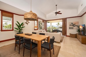 A dining area with a wooden table and chairs, a ceiling fan, and a view of the outdoors. - Big Island Kolea by Coldwell Banker Island Vacations (Waikoloa)