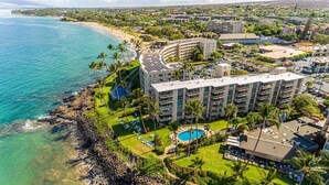 Un resort con piscina, varias construcciones y una playa.