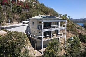 Un immeuble de deux étages doté d’un balcon, de panneaux solaires et offrant une vue sur la mer.