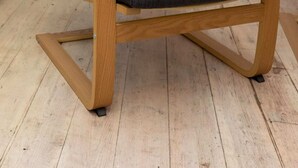 A wooden chair with a dark fabric seat and backrest, featuring a curved wooden frame and a metal base. - Serene and Spacious 1 Bedroom Garden Flat in Clapton (London)