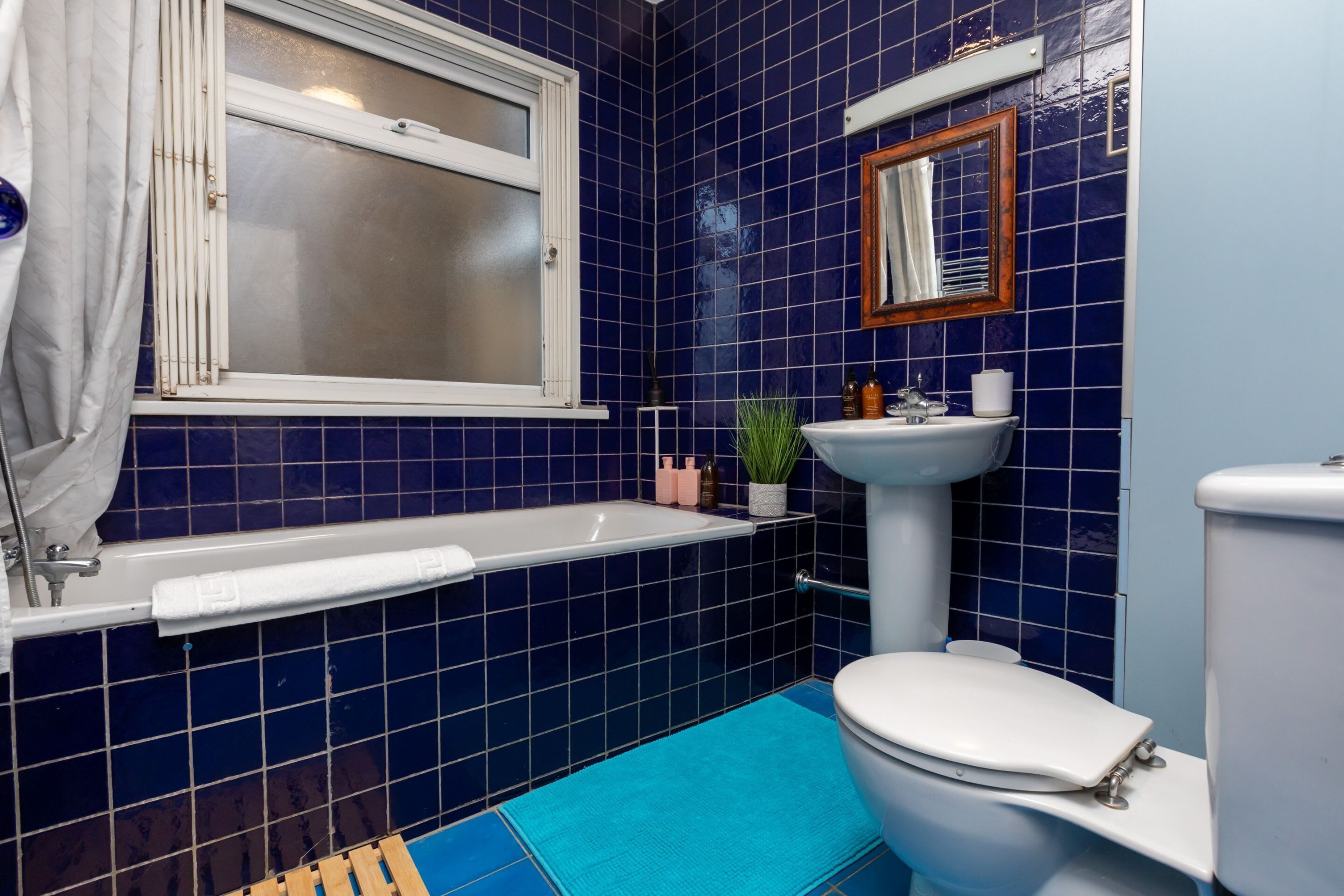 Ein Badezimmer mit Badewanne, Waschbecken und Toilette, alles in Weiß.