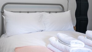 A neatly made bed with white linens and a pink throw blanket. - Serene and Spacious 1 Bedroom Garden Flat in Clapton (London)