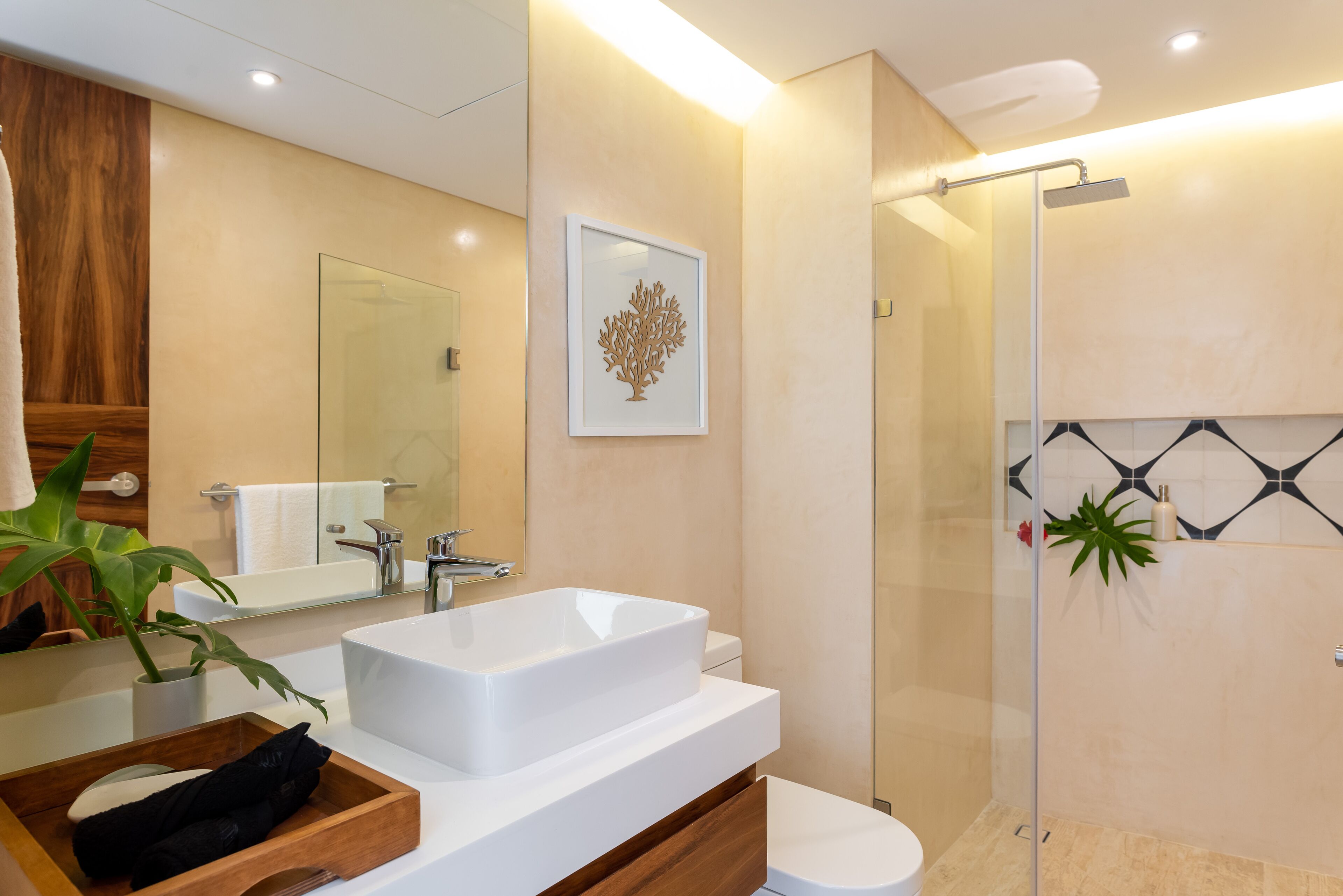 Une salle de bain moderne avec un grand lavabo blanc, une douche en verre et un meuble-lavabo en bois.