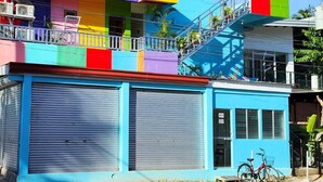 Un edificio con fachada colorida, un cerrojo azul cerrado y una bicicleta estacionada afuera.