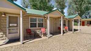 A motel with a covered outdoor seating area, numbered rooms, and a gravel driveway. - Mt Carmel Motel Room close to Zion National Park! (Orderville)