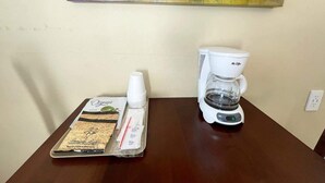 A coffee maker and a tray with coffee pods and a bottle on a table. - Mt Carmel Motel Room close to Zion National Park! (Orderville)