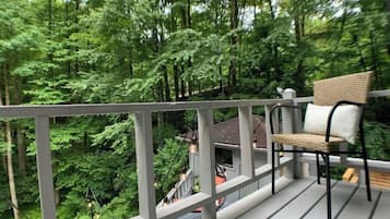 Relax on the deck with a wicker chair and take in the serene forest views.