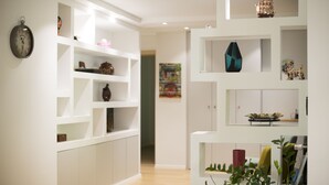 Un intérieur moderne avec des étagères blanches où sont exposés divers objets décoratifs.