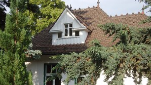 A traditional house with a steeply pitched roof, a dormer window, and a visible chimney.