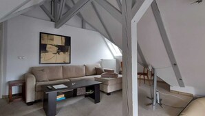 A modern living room with a sectional sofa, a coffee table, and a painting on the wall.