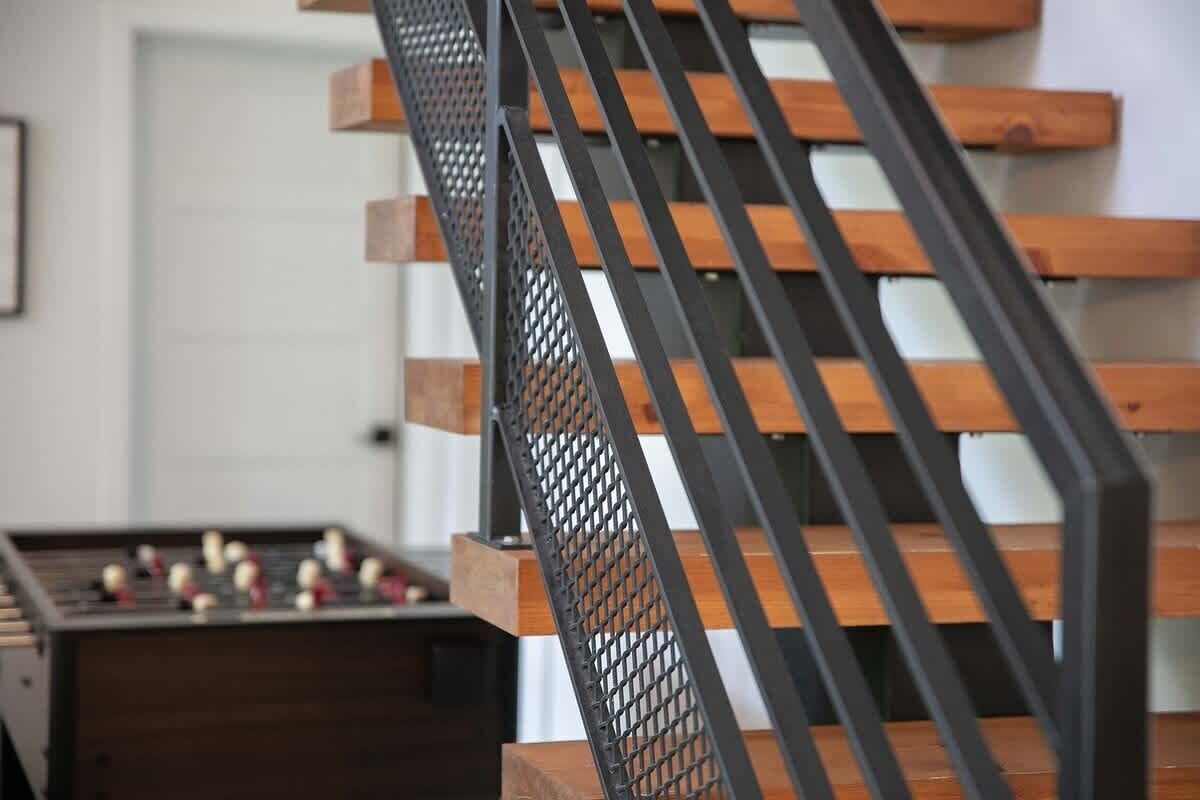 Una escalera con escalones de madera y barandillas de metal.