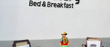 Segno di un ostello Clary Bed & Breakfast, due poltrone a dondolo in legno e un tavolino con una figurina decorativa.