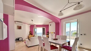 A dining area with a white table and chairs, a ceiling fan, and a view through a glass door to the outside. - WE ARE LOCATED IN A VERY EXCLUSIVE AREA, WHO WOULD  KNOW?
 (Sicilia)
