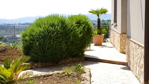 A balcony with a view of mountains, a potted plant, and a stone wall. - WE ARE LOCATED IN A VERY EXCLUSIVE AREA, WHO WOULD  KNOW?
 (Sicilia)
