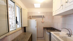 A compact kitchen with a refrigerator, a stove, and a sink. - Florio house 300 (Santa Maria di Leuca)
