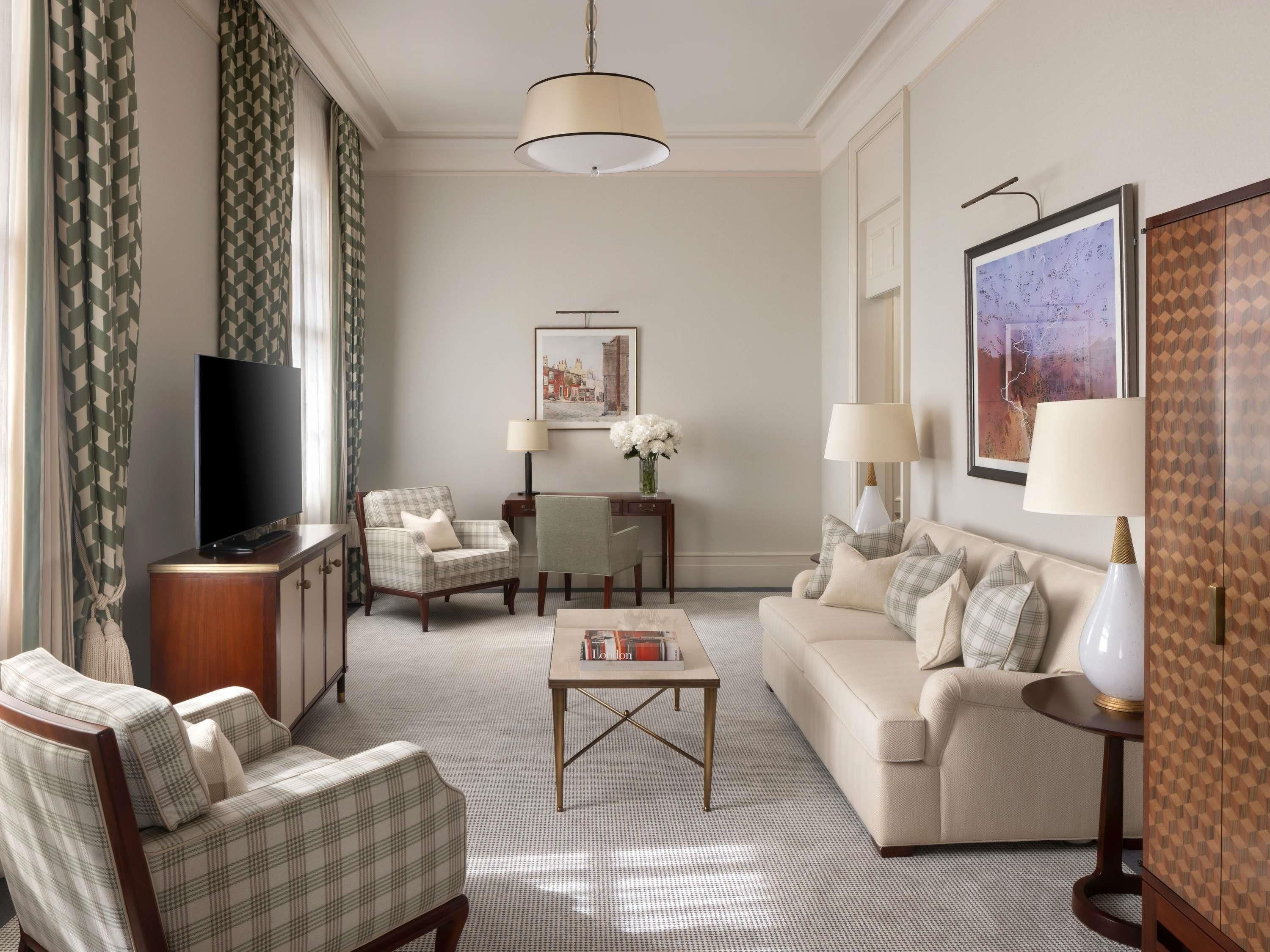 A living room with a television, two armchairs, a sofa, a coffee table, and a lamp.