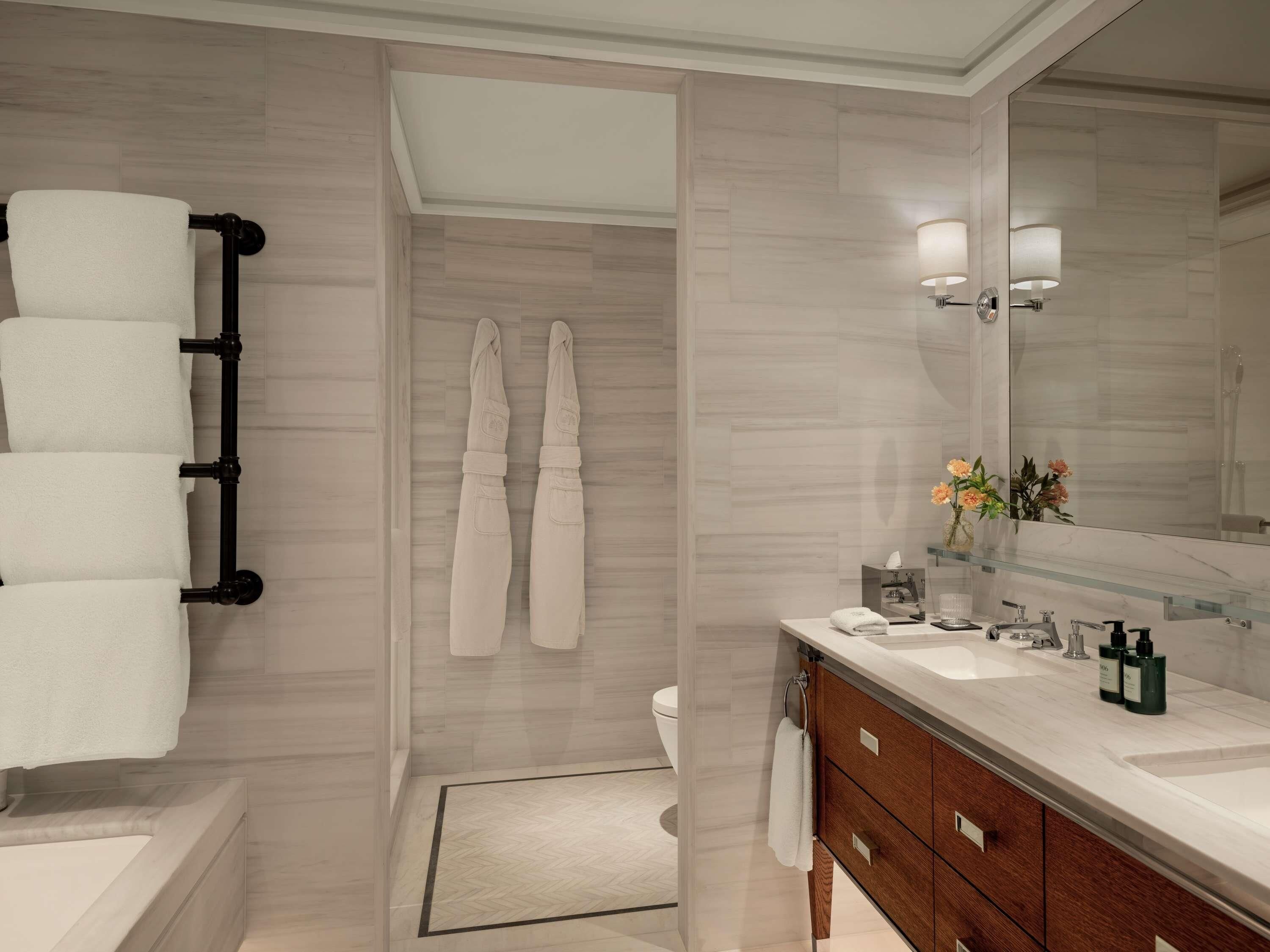 A modern bathroom with a bathtub, a vanity with a mirror, and a shower area.