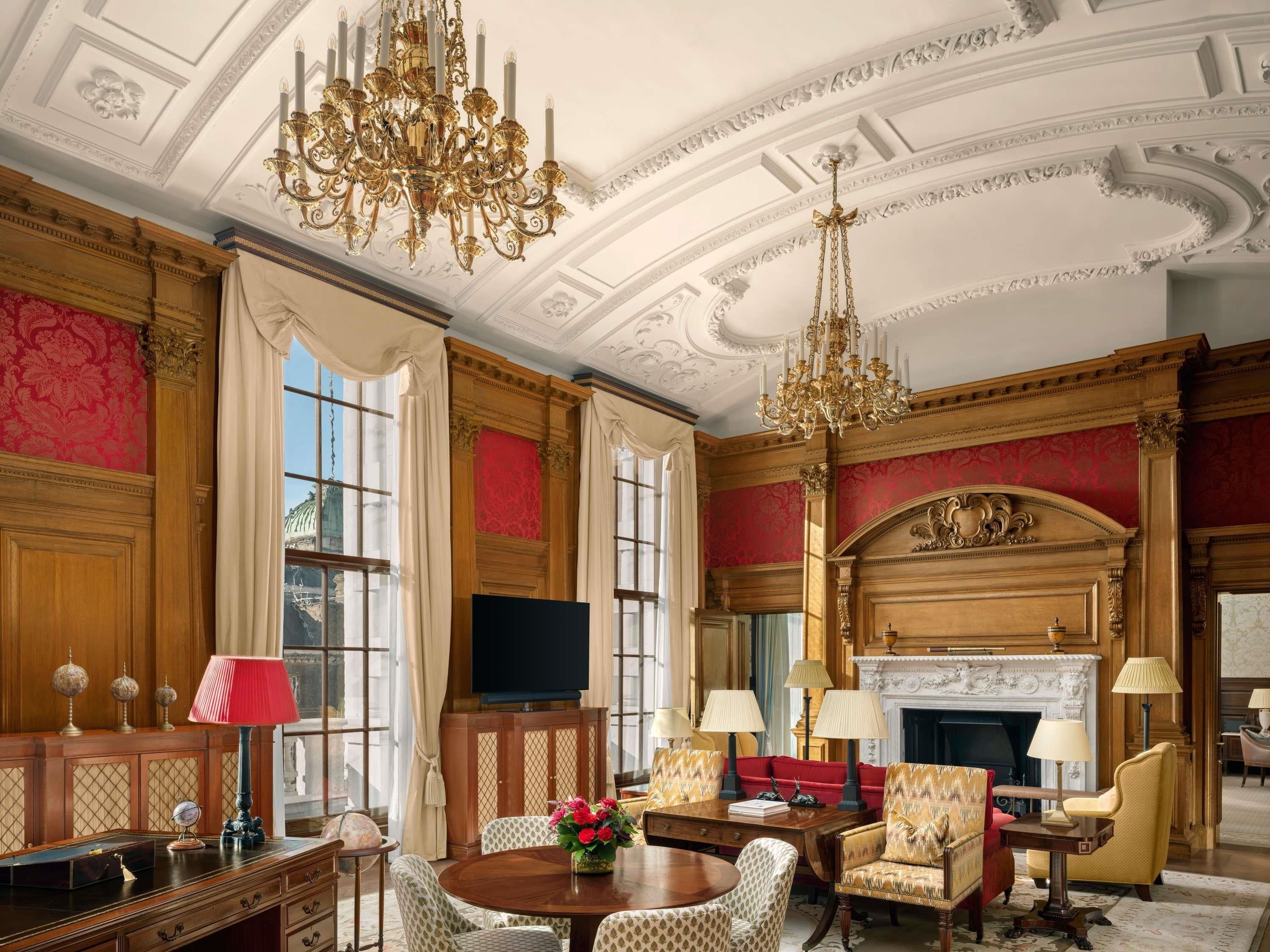 A luxurious room with a fireplace, ornate chandeliers, and classic furniture.