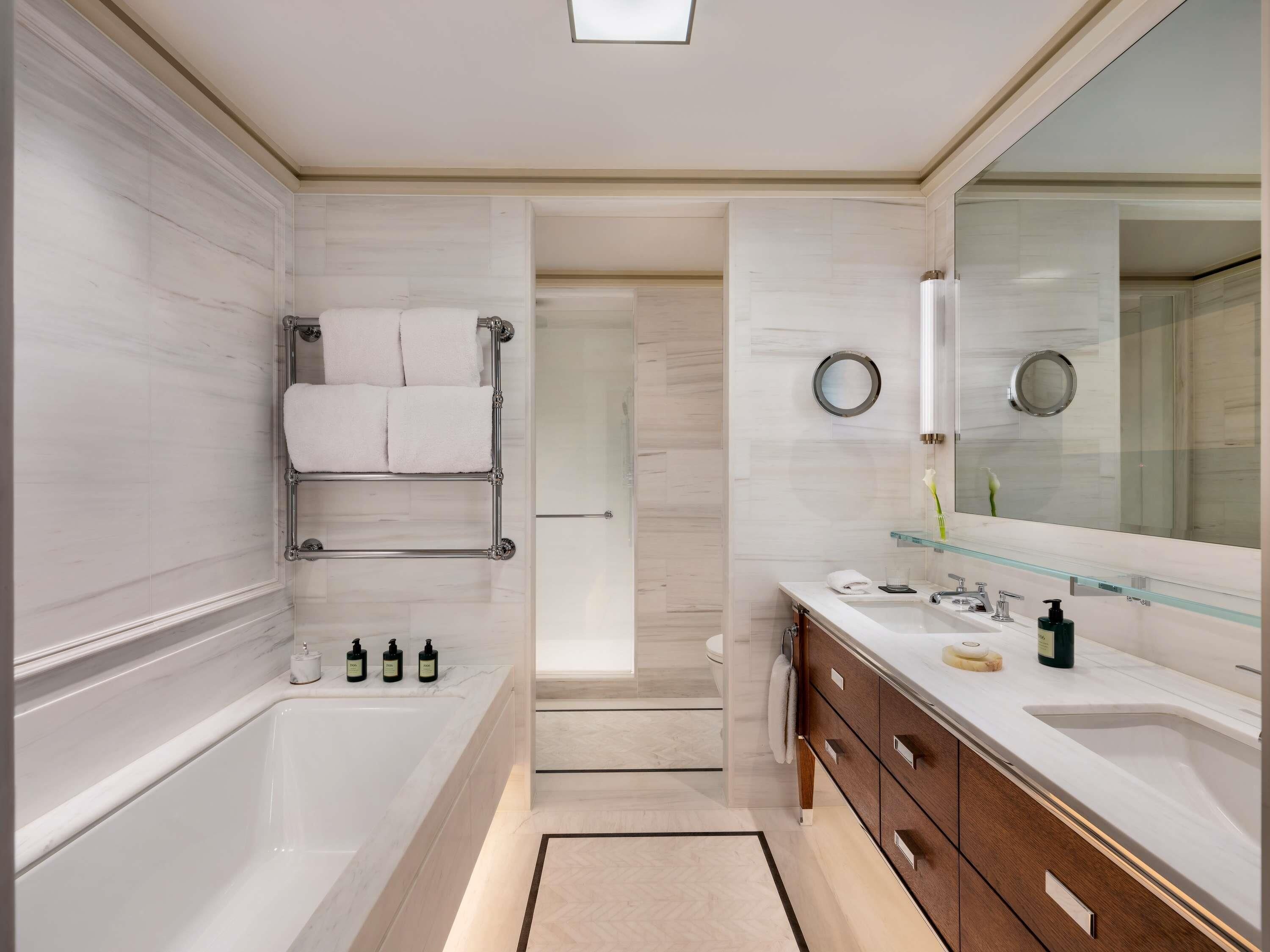 Un baño moderno con bañera, cabina de ducha de vidrio, tocador con espejo y un inodoro.