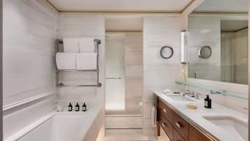 Un baño moderno con bañera, cabina de ducha de vidrio, tocador con espejo y un inodoro.