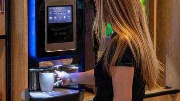 Una persona usando una máquina de café con pantalla digital.