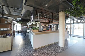 A modern bar area with a counter, seating, and a large window. - Ibis Bourgoin Jallieu Medipole (Bourgoin-Jallieu)