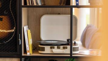 Una estantería con discos de vinilo, un tocadiscos y libros.