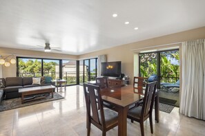 A spacious living area with a dining table, chairs, a sofa, and a television. - Wailea Elua, #2101 1 Bedroom Condo by RedAwning (Kihei)