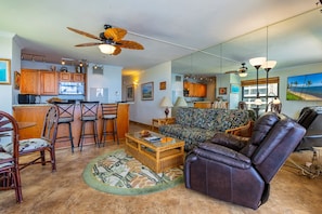 A living room with a sofa, chairs, a coffee table, and a kitchen in the background. - Sugar Beach Resort, #414^ 1 Bedroom Condo by RedAwning (Kihei)