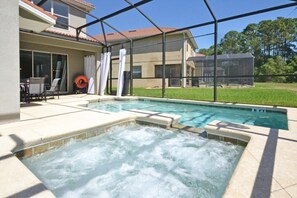 A swimming pool with a hot tub area, surrounded by a covered patio and a house. - Casa Palmero 5 Bedroom Home by RedAwning (Kissimmee)