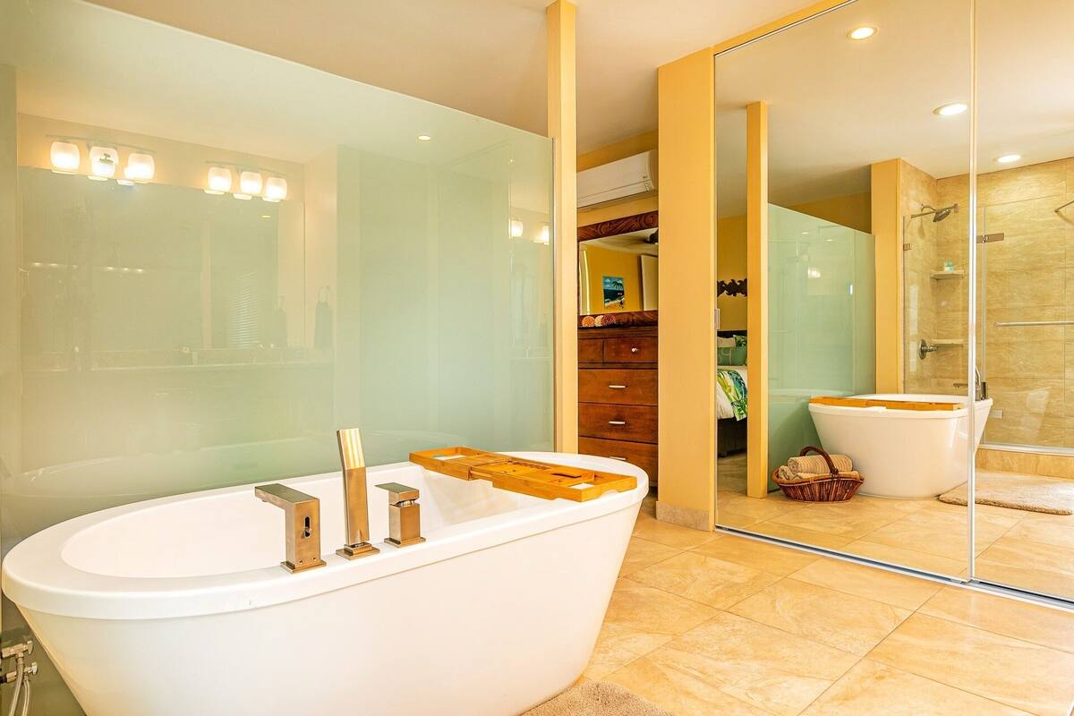 A modern bathroom with a freestanding bathtub, a glass shower enclosure, and a wooden vanity.