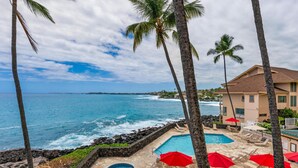 A resort with a pool area, palm trees, and ocean views. - Big Island Sea Village 3212 2 Bedroom Condo (Kailua-Kona)