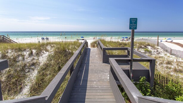 A wooden boardwalk leading to a beach with a sign indicating it's for residents and guests only. - Sweet Spot - Newly Renovated, Heated Pool, Golf Cart, Deeded Beach Access! (Miramar Beach)