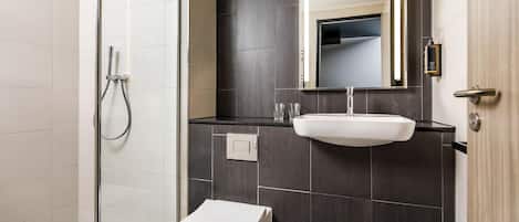 Une salle de bain moderne équipée d’une douche, d’un lavabo et de toilettes.